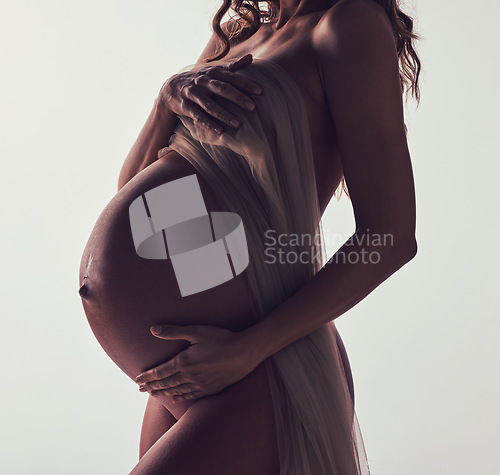 Image of Woman, pregnant and fabric on stomach in studio with hands, touch and art by white background. Pregnancy model, shadow and mom wellness with cloth for body, belly and silhouette with dark aesthetic