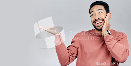 Image of Product placement, happy and an Asian man showing mockup isolated on a white background. Excited, looking and a guy gesturing to space for branding, advertising and marketing on a studio backdrop