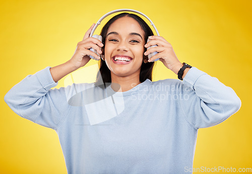 Image of Laugh, music and headphones with portrait of woman in studio for streaming, online radio and audio. Smile, media and podcast with female on yellow background for technology, listening and connection
