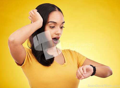 Image of Late, watch and surprise of a woman in a studio looking at time with alarm feeling shocked. Isolated, yellow background and young female model with shock from watching the clock and smartwatch