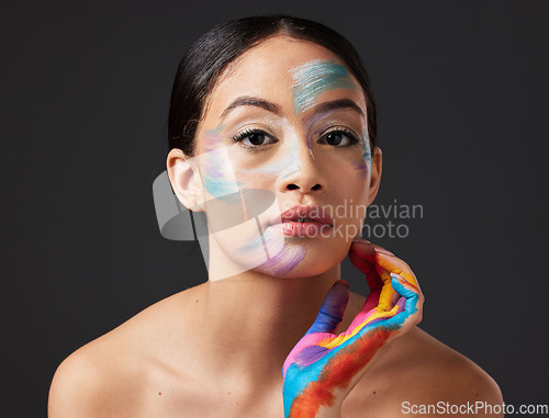 Image of Woman, face and beauty portrait with color paint art on hand in studio. Creative skin and makeup on female aesthetic model on gray background for lgbtq rainbow inspiration hands or facial cosmetics