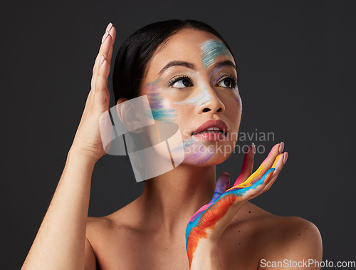 Image of Beauty, art and woman with paint on face and hands, creative makeup and self expression. Aesthetic, creativity and artistic color cosmetics, skincare and freedom to express for young beautiful girl.