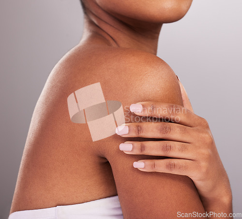 Image of Woman, hands and shoulder in skincare beauty, cosmetics or body care against a gray studio background. Hand of female touching shoulders in cosmetic treatment for self love or soft and perfect skin