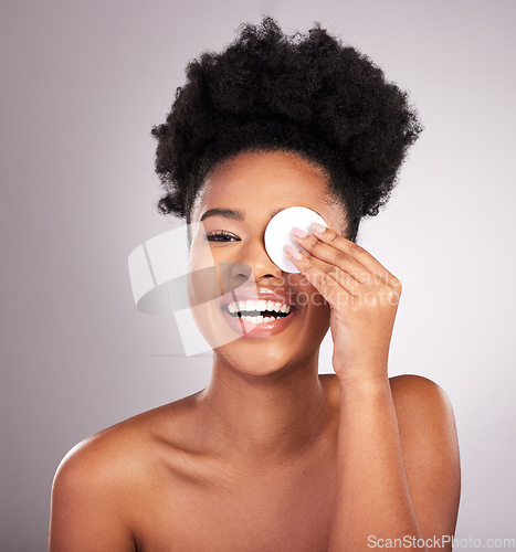 Image of Black woman, skincare and cotton on eye in studio with cleaning, makeup removal or laugh by background. Young model, wipe and clean skin for natural glow, comic smile or cosmetic health for self care