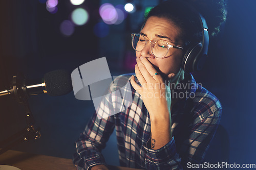 Image of Tired, dark and a woman yawning in radio broadcast, podcast production and late shift. Fatigue, overworked and a media reporter with a yawn while streaming at night with burnout, boredom and sleepy