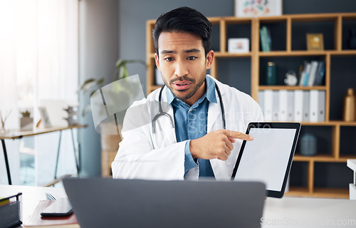 Image of Mockup, pointing and a doctor on a video call with a tablet for results, healthcare support and advice. Talking, consulting and an Asian gp with a blank screen tech for a telehealth webinar on a pc