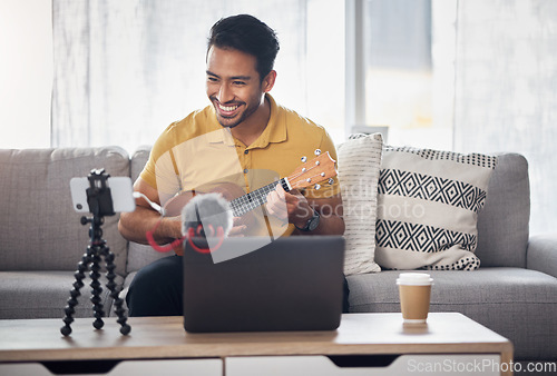 Image of Guitar, streaming and phone with a man talking online to coach during live lesson. Asian male influencer happy on home sofa with a ukulele as content creator teaching music on education podcast blog