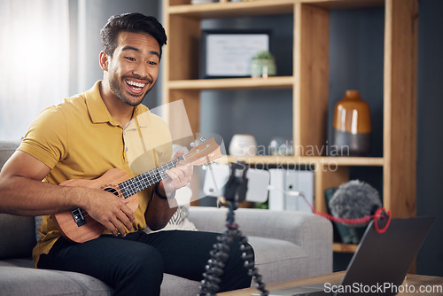 Image of Phone, guitar tutorial and man with a smile online to coach during live streaming lesson. Asian male influencer happy on home sofa with a ukulele as content creator teaching music on education blog