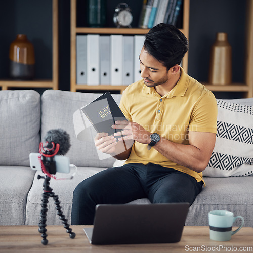 Image of Christian man, bible and study with phone and microphone online while live streaming. Asian male on home sofa with holy book on religion as blog content creator or influencer teaching on podcast