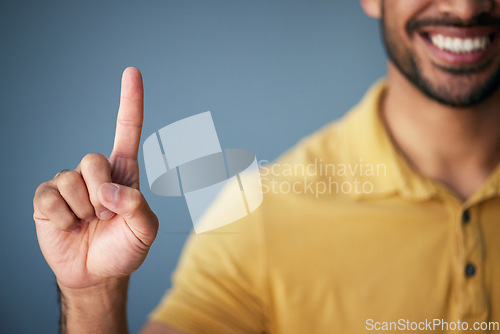 Image of Asian man, hand and smile, pointing up in studio with mockup for choice or vote on blue background. Location, finger showing deal announcement or information with happy mock up space for notification