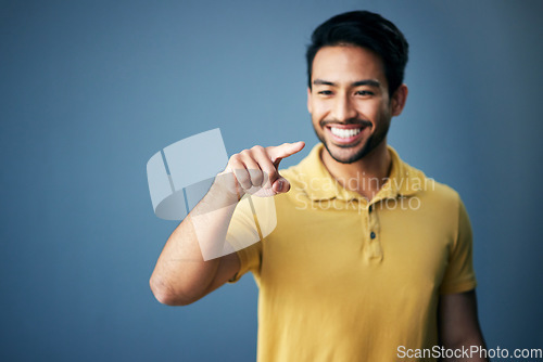 Image of Mockup, smile and Asian man pointing, space and product placement against blue studio background. Japan, male and happy guy with brand development, happiness and suggestion with promotion and choice
