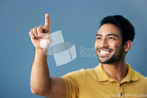 Image of Finger, pointing and happy man in studio with hand gesture, sign or showing mockup on blue background. Smile, point and asian male with idea on space for advertising, product placement and isolated