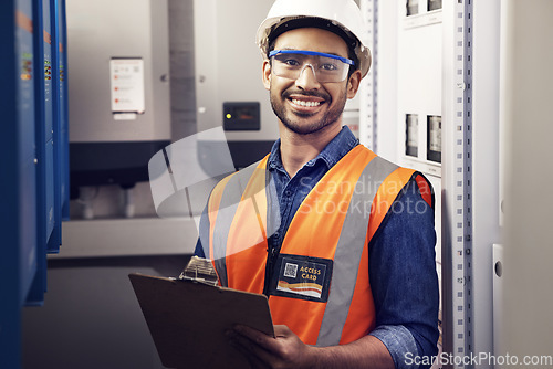 Image of Portrait, happy man and engineering technician at control panel, inspection and planning maintenance on clipboard. Male electrician smile at electrical substation, power system and mechanic checklist