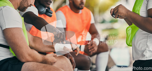 Image of Injury, sports and a man with a bandage at rugby, wrapping wrist and accident at a game. Team, playing and men protecting a hand of a player after a broken bone during sport competition or match