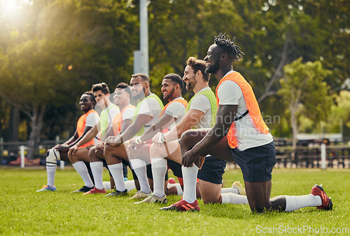 Image of Rugby sport, diversity and men training outdoor on a grass field with a team happy for knee exercise. Athlete group together for fitness, motivation and workout for sports club and strong teamwork