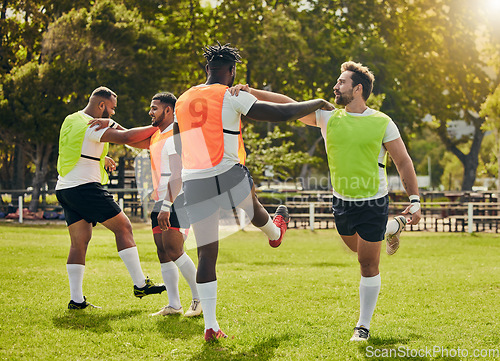 Image of Sports, rugby men and training outdoor on grass field with team stretching legs as warm up. Male athlete group together for fitness, exercise and workout for sport with support and club teamwork