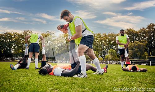 Image of Sports, rugby and outdoor stretching legs on a grass field with a team doing warm up. Athlete men group together for fitness, exercise and workout for professional sport with coach and teamwork