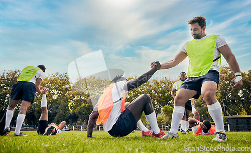 Image of Teamwork, helping hand or rugby men in training, exercise or workout in practice match on grass field. Challenge, strong man or powerful group in tough competitive sports game with physical fitness