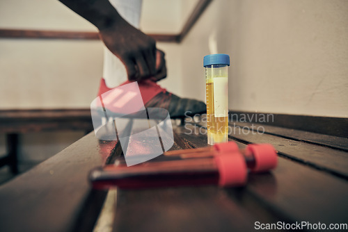 Image of Rugby, blood and urine sample in a locker room for sports regulations or anti doping testing. Fitness, health and medical with an athlete getting ready after a drug test for an illegal substance