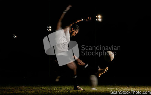 Image of Rugby, night and man kicking ball to score goal at dark stadium at game, match or practice workout. Sports, fitness and motion, player with blurred action on grass with energy and skill in team sport