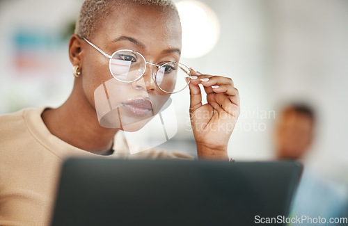 Image of Office, computer and black woman with glasses, serious or reading email, online research or report. Laptop, concentration and African journalist proofreading article for digital news website or blog