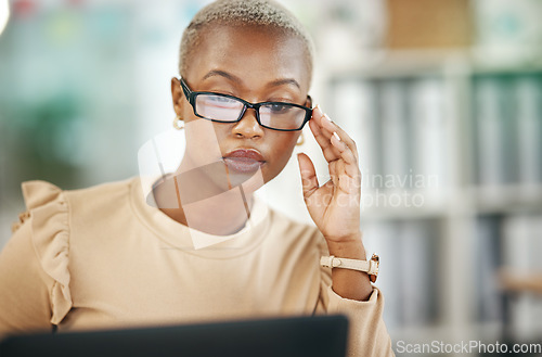 Image of Laptop, serious and black woman with glasses, reading email or online research report in office. Computer, concentration and African journalist proofreading article for digital news website or blog.