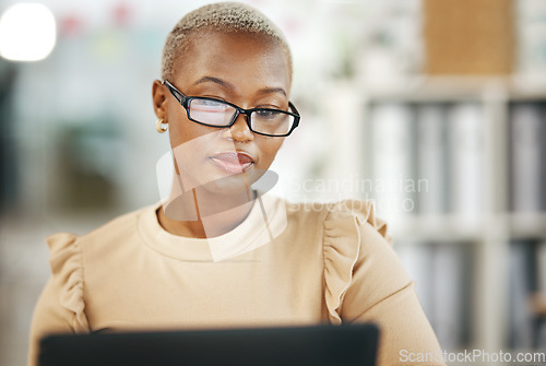 Image of Office, laptop and black woman with glasses, internet research and checking online report or email. Computer, concentration and serious, African journalist working on article on digital news website