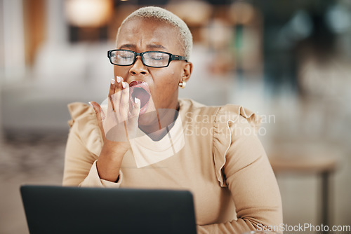 Image of Office, laptop and yawning black woman with glasses, reading email or online research report at night. Computer, overtime and tired African journalist working late on article for digital news website
