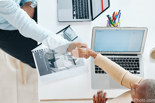 Image of Creative business people, handshake and laptop above on mockup screen for teamwork collaboration at office. Top view of employee designers shaking hands for meeting, partnership or startup agreement