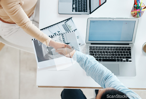 Image of Creative business people, handshake and laptop above on mockup screen for teamwork collaboration at office. Top view of employee designers shaking hands for meeting, partnership or startup agreement