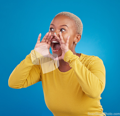 Image of Screaming, announcement and loud with a black woman on a blue background in studio for news or communication. Hand, shouting or message and a young female yelling to alert danger with her voice