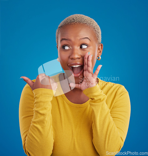 Image of Black woman, gossip and secret in studio with hand on face for sale announcement. African female model on a blue background to whisper message, news information or wow rumor pointing at mockup deal