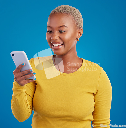 Image of Phone, happy and black woman typing in studio for social media, text message and browse website. Communication mockup, technology and girl on internet, networking and chat online on blue background
