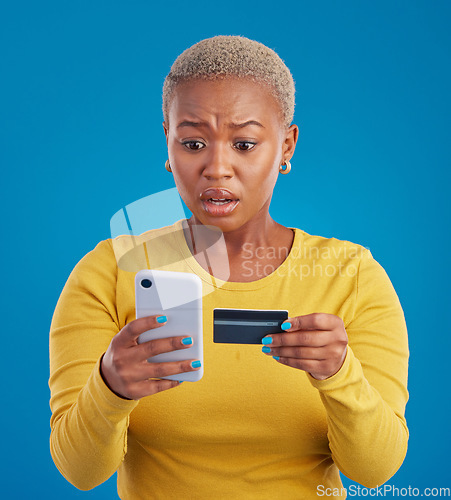 Image of Credit card, phone and worried woman online shopping mistake, transaction fail or debt isolated on blue background. Stress, anxiety and confused person fintech payment, hacking or phishing in studio