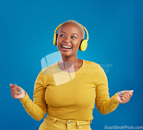 Image of Black woman with headphones, dancing and listen to music, rhythm and fun with freedom on blue background. Happy female with yellow aesthetic, streaming radio with dance and carefree in studio