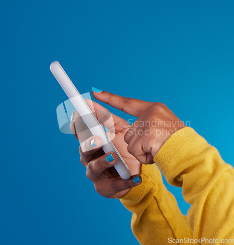 Image of Phone, typing and hands of woman point to screen in studio for social media, text message and website. Communication, technology and girl on internet, networking and chat online on blue background