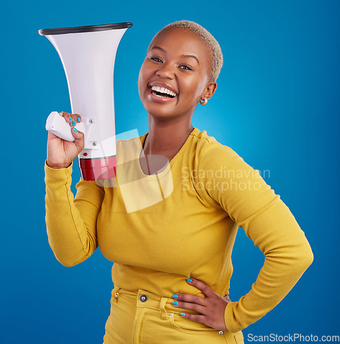 Image of Black woman, megaphone and happy, protest and voice, freedom of speech and activism on blue background. Female smile, broadcast and speak out, rally and portrait, loudspeaker with opinion in studio