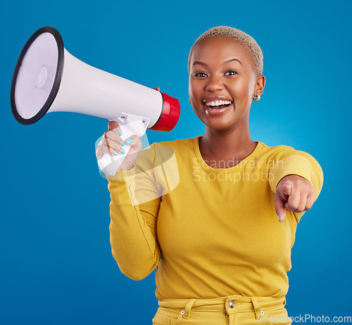 Image of Black woman, megaphone and pointing, protest and voice, freedom of speech and activism on blue background. Happy female, broadcast and speak out, rally and portrait, loudspeaker and opinion in studio