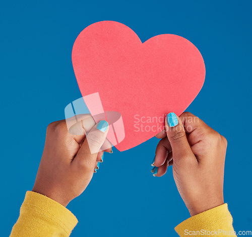 Image of Paper, heart and hands of black woman in studio for love, date and kindness. Invitation, romance and feelings with female and shape isolated on blue background for emotion, support and affectionate