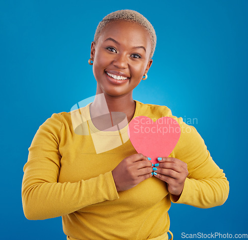 Image of Paper heart, happy black woman and portrait in studio, blue background and backdrop. Smile, female model and shape for love, wellness and support of peace, thank you and kindness on valentines day