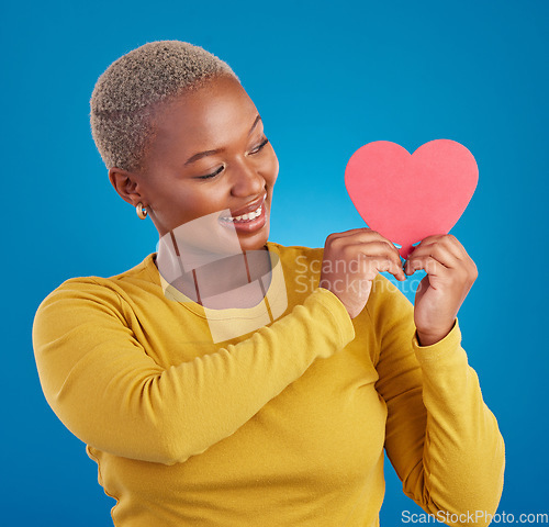 Image of Paper, heart and happy with black woman in studio for love, date and kindness. Invitation, romance and feelings with female and shape isolated on blue background for emotion, support and affectionate