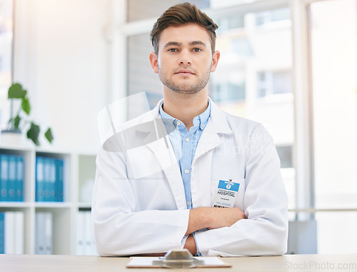 Image of Medical, serious and portrait of assertive doctor man in a hospital office feeling confident, focus and proud in clinic. Young medicine expert and healthcare professional with arms crossed for health
