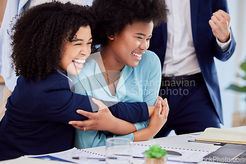 Image of Business woman, friends and hugging in congratulations for promotion, sale or bonus at the office desk. Women hug in celebration for corporate success, teamwork or support for winning or achievement