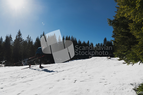 Image of Nordic skiing or Cross-country skiing classic technique practiced by man in a beautiful panoramic trail at morning.