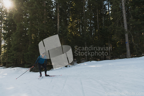 Image of Nordic skiing or Cross-country skiing classic technique practiced by man in a beautiful panoramic trail at morning.