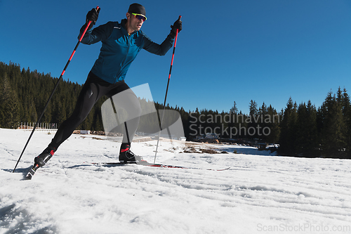 Image of Nordic skiing or Cross-country skiing classic technique practiced by man in a beautiful panoramic trail at morning.