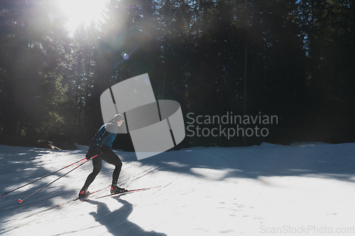 Image of Nordic skiing or Cross-country skiing classic technique practiced by man in a beautiful panoramic trail at morning.