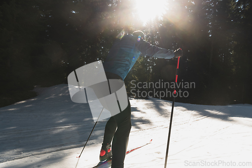 Image of Nordic skiing or Cross-country skiing classic technique practiced by man in a beautiful panoramic trail at morning.