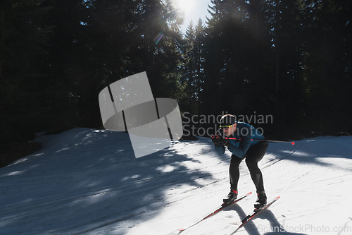 Image of Nordic skiing or Cross-country skiing classic technique practiced by man in a beautiful panoramic trail at morning.