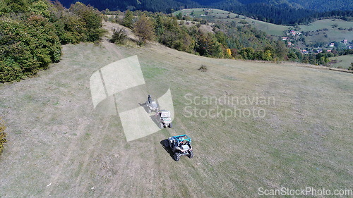 Image of Aerial drone view of ATV quads on a dirt trail in forests. Off-road group team club enthusiasts having fun while driving countryside roads.